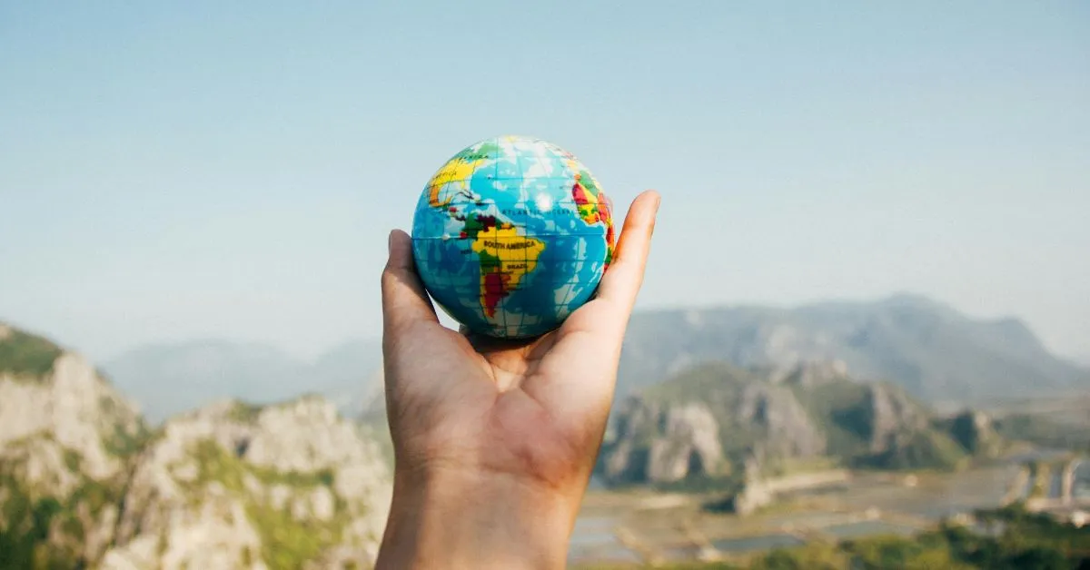 image of hand holding a small globe